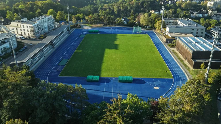 Vue aérienne d’un stade entouré d’une piste d’athlétisme bleue