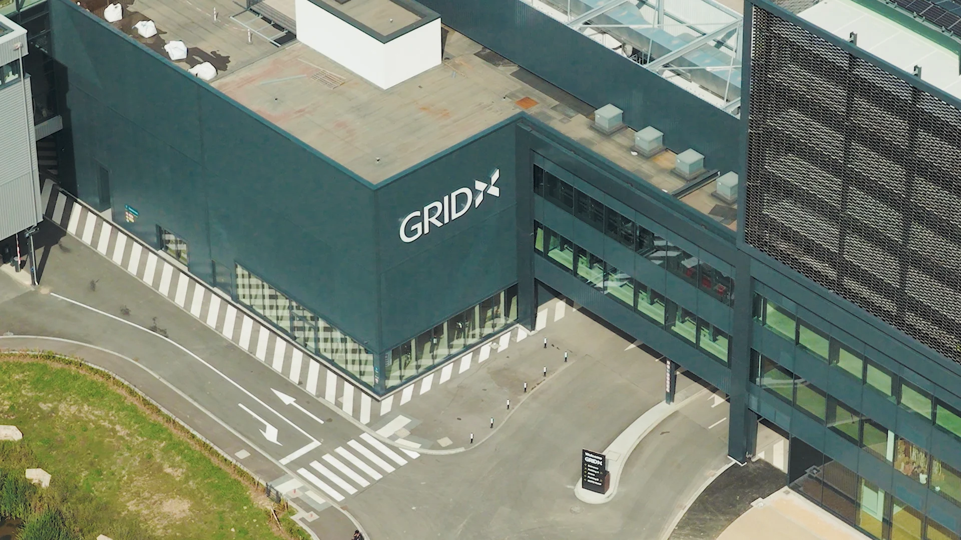 GRIDX façade with its signage, forecourt and circulation routes at the base of the building.