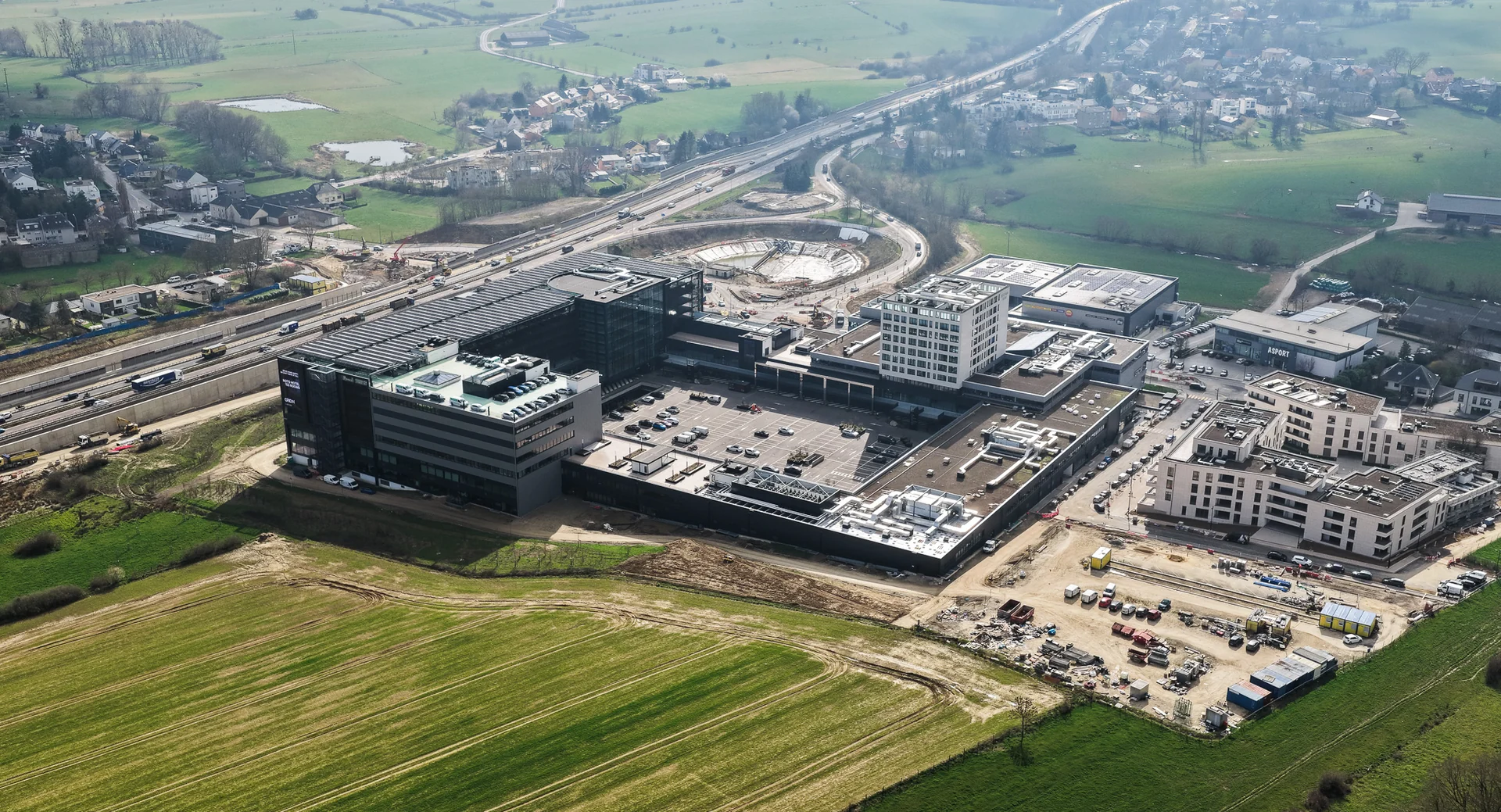 Aerial view of GRIDX, its roofs and surroundings, with construction areas visible.